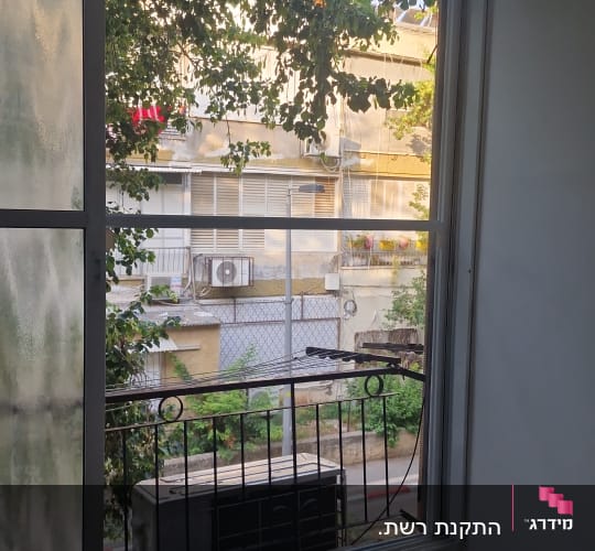 חלון אלומיניום עם מסגרת מתכת נראית מבחוץ